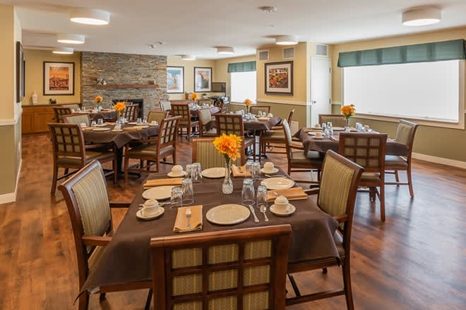 A cozy dining room interior with neatly set tables and comfortable chairs.