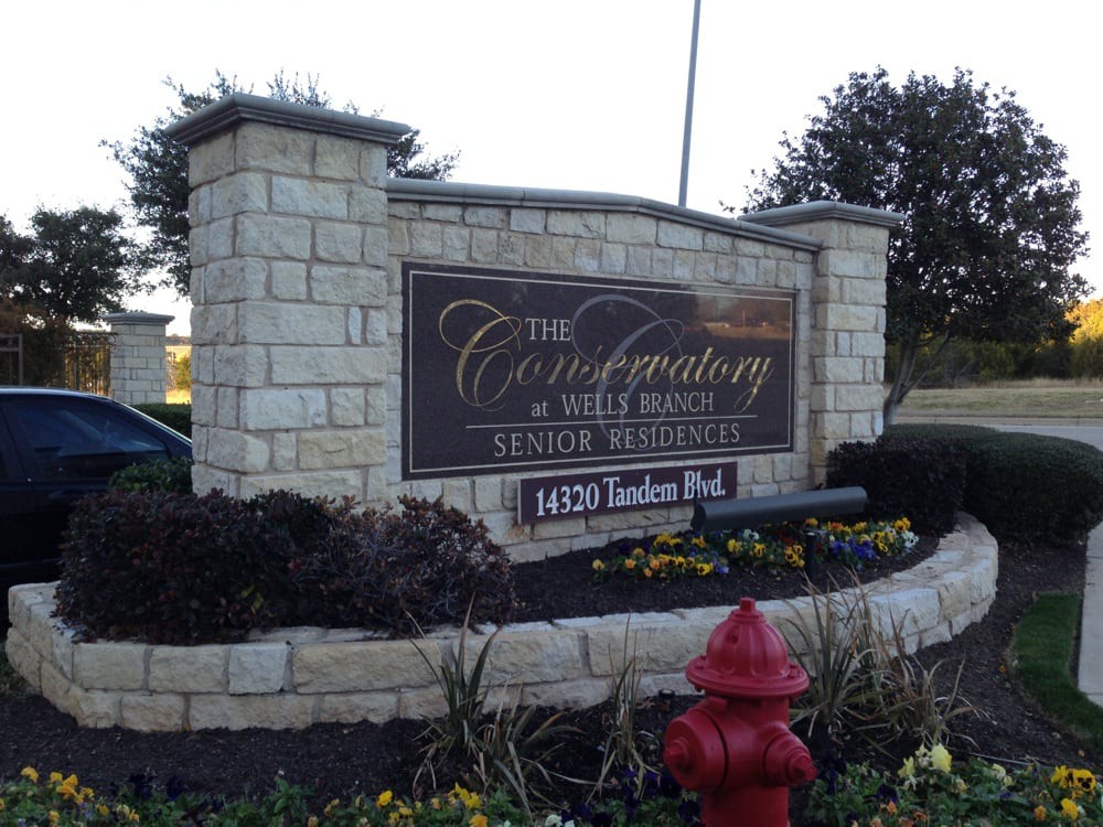 Entrance sign for The Conservatory at Wells Branch Senior Living.