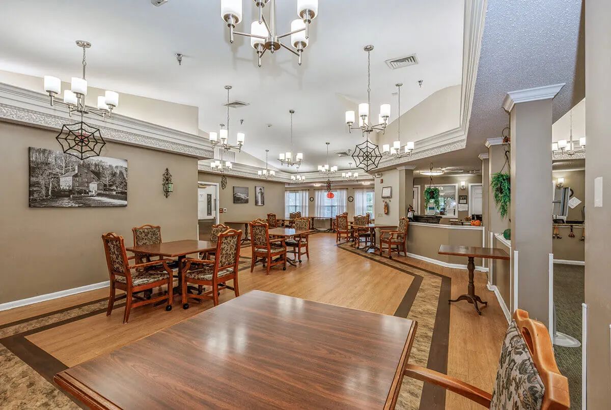 A spacious dining area with elegant chandeliers and wooden furnishings.
