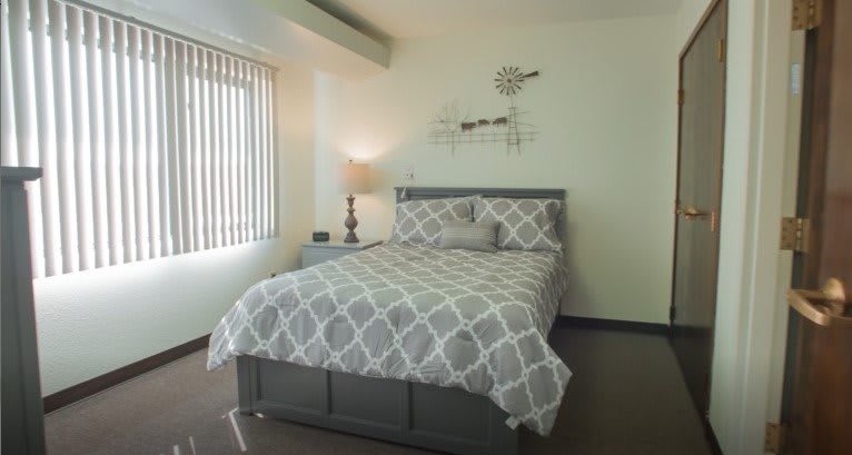 A cozy bedroom with a patterned bedspread and modern decor.