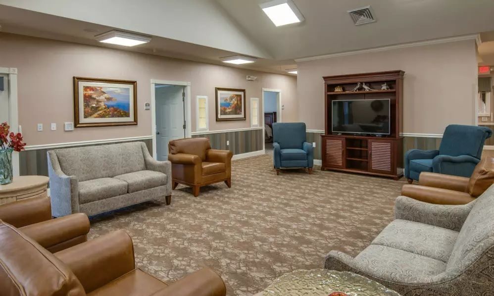 A cozy living room with comfortable seating and a TV entertainment center.