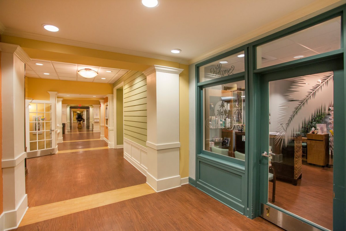 A well-lit hallway with wooden flooring and decorative walls.