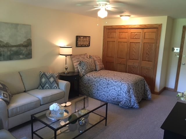 A well-decorated bedroom with a bed, sofa, and closet.
