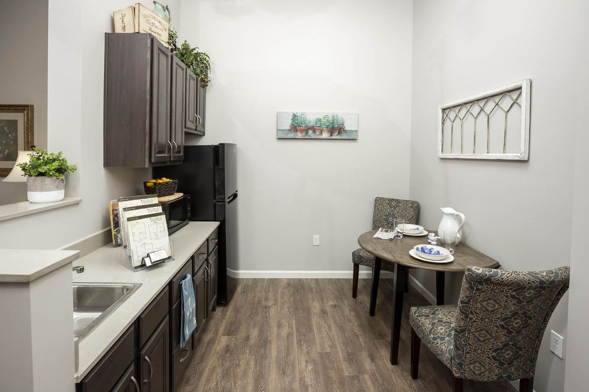 A modern kitchen interior with dark cabinets, a small dining area, and contemporary decor.