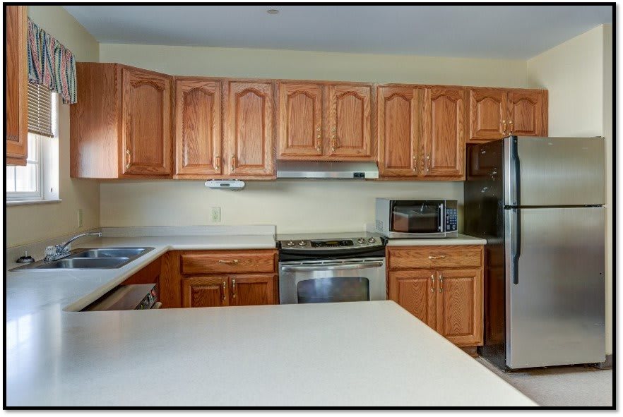 A modern kitchen featuring wooden cabinets and stainless steel appliances.