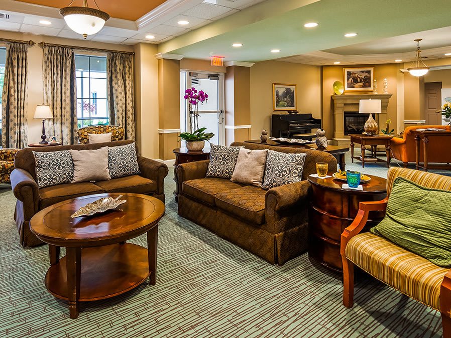A cozy living room with sofas and a coffee table, featuring warm lighting and decorative elements.