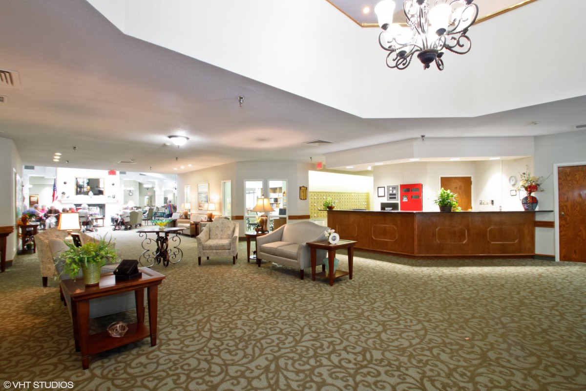 A spacious hotel lobby with a reception desk and comfortable seating.