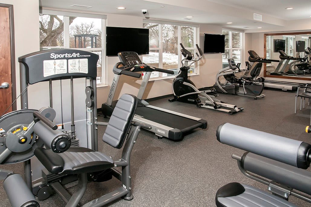 A modern gym equipped with various exercise machines, including treadmills and stationary bikes.