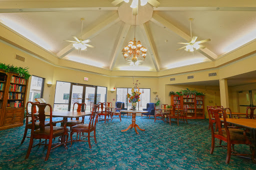 A spacious lounge area with elegant seating and abundant natural light, featuring ceiling fans and a cozy atmosphere.