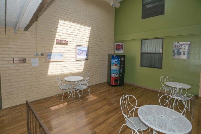 A cozy indoor seating area with tables, chairs, and a vending machine.