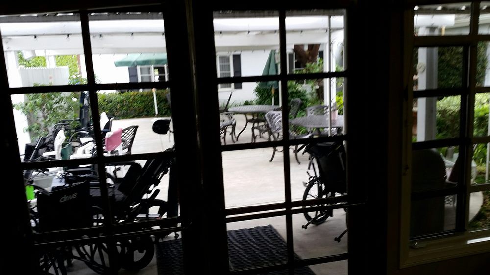 View of an outdoor patio area with tables, chairs, and bicycles seen through a window.