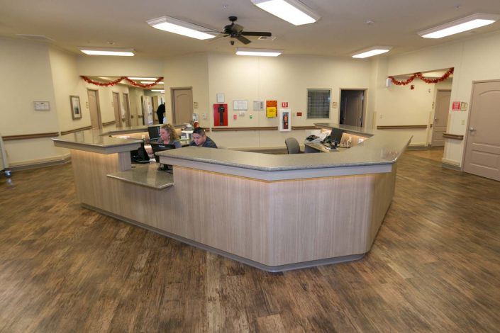 A modern office reception area with a large central desk and computer equipment.