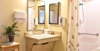 A bathroom interior featuring a sink with a large mirror above it.