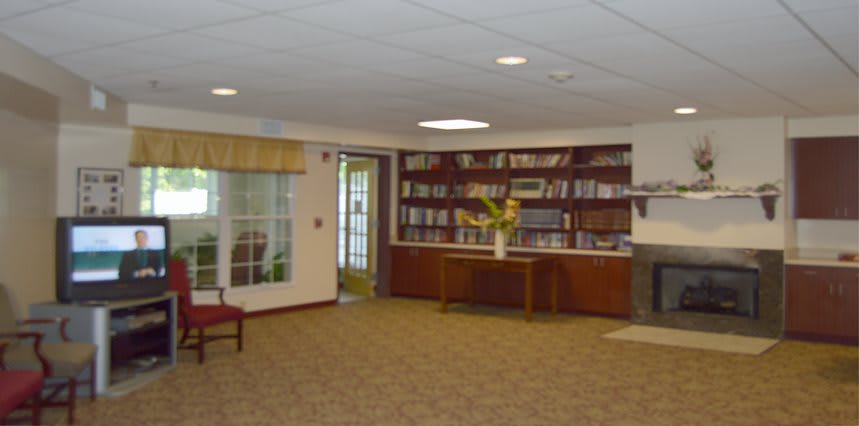 A library reading room with bookshelves and comfortable seating.