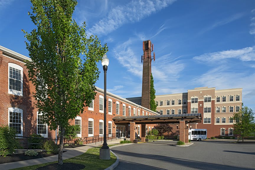 A brick building with a chimney and trees under a clear blue sky.