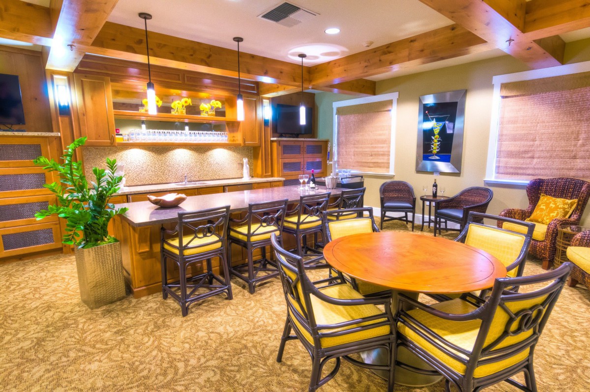 A modern bar area with wooden furniture and ambient lighting.