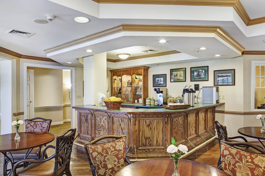 A cozy cafe interior featuring a wooden counter and seating area.