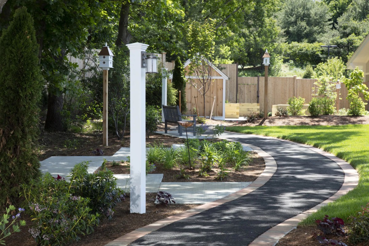 A serene garden pathway surrounded by lush greenery.