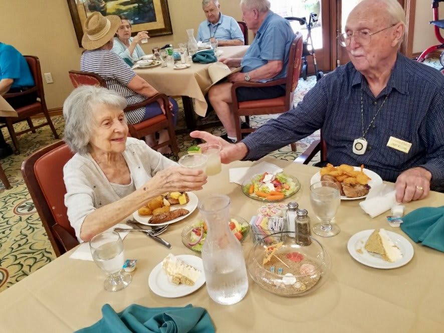 Elderly individuals enjoying a meal together in a dining setting.