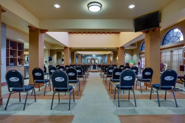 An empty conference room set up for a meeting, with rows of chairs lined up.
