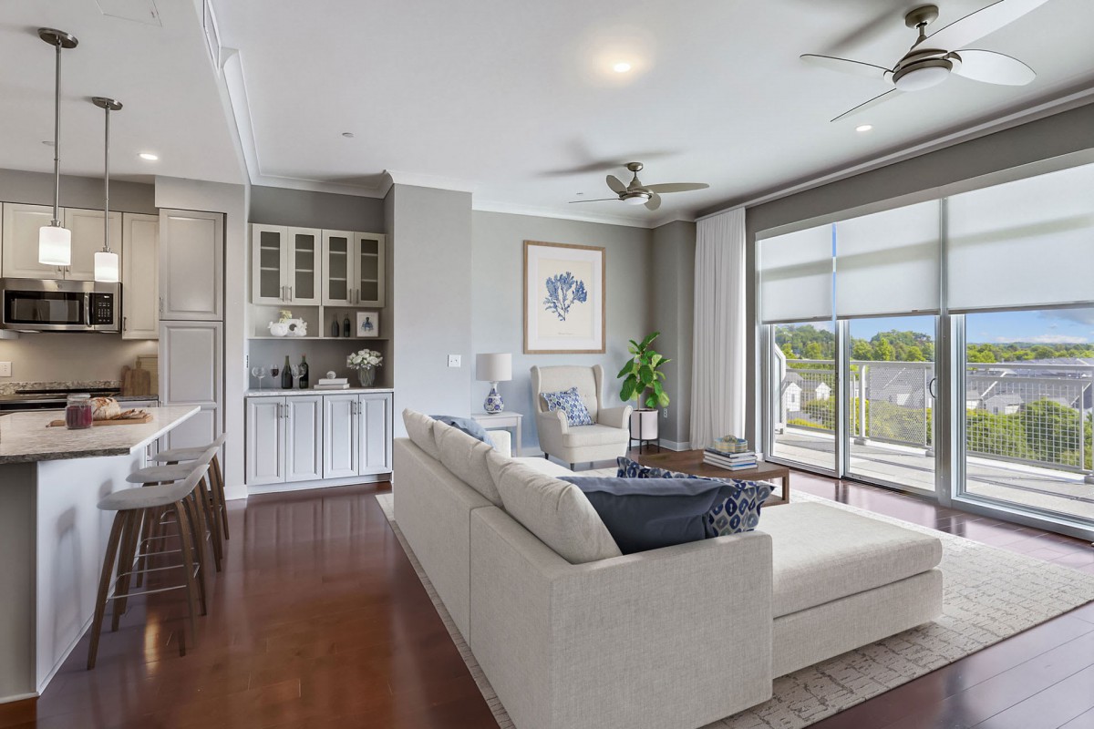 A modern and spacious living room featuring a comfortable sofa, large windows, and elegant decor.