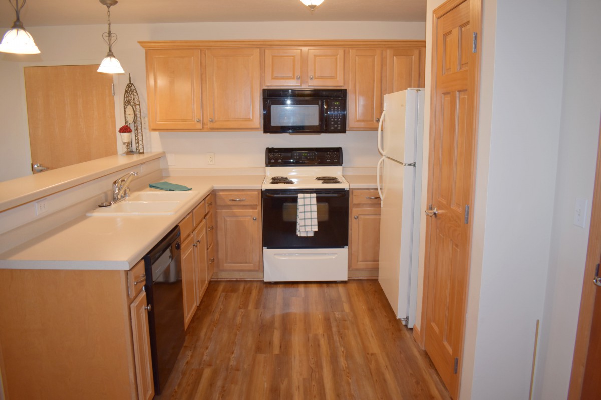 A cozy kitchen with wooden cabinets and modern appliances.