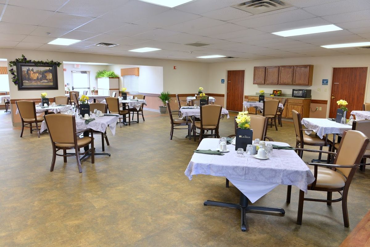 An empty dining room with neatly arranged tables and chairs.