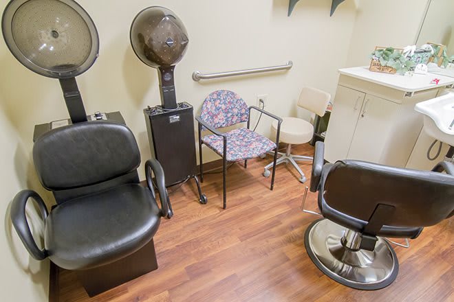 A cozy salon interior with styling chairs and a hair dryer.