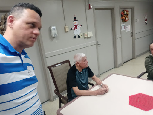 Two individuals engage in conversation at a table in a communal setting.