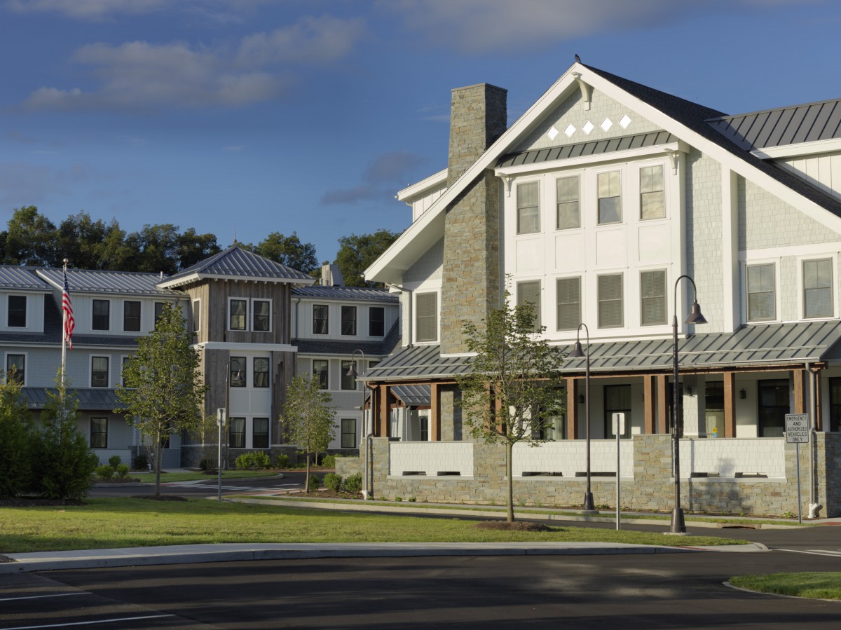 A modern suburban residential building with a stone facade and large windows.