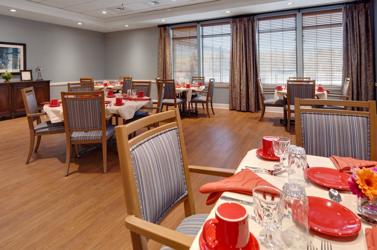 An elegantly set dining area with red accents and neatly arranged tables.