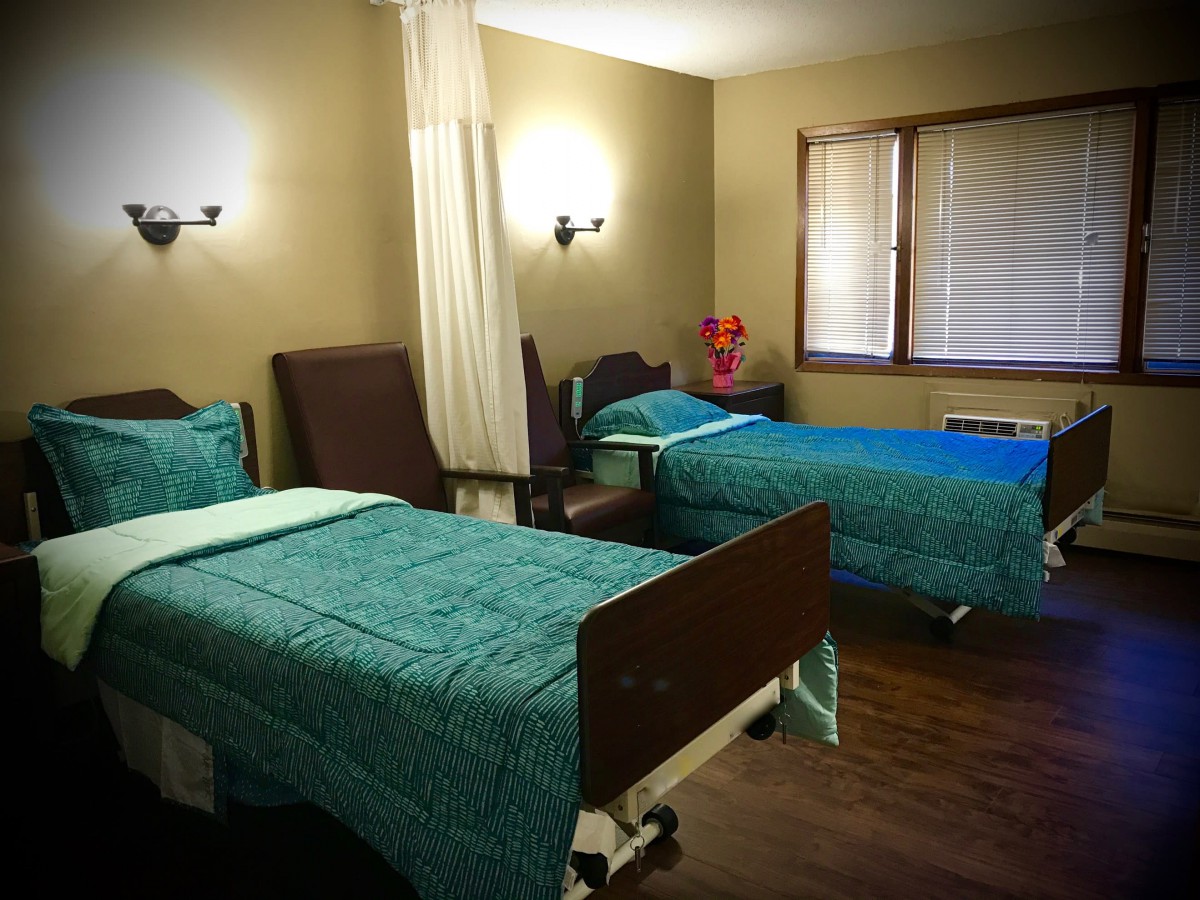 A hospital room with two neatly made beds, ready for patients.