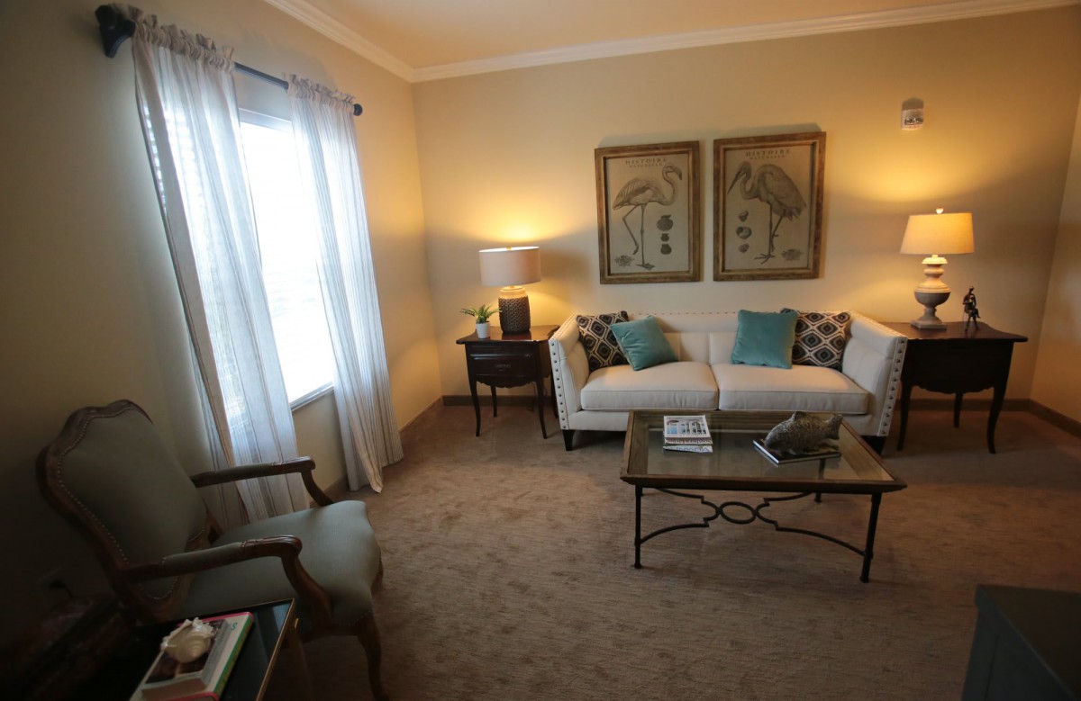 A cozy living room with a sofa, coffee table, and warm lighting.