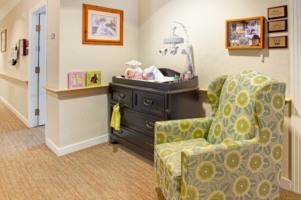 A cozy nursery corner with a changing table and patterned armchair.