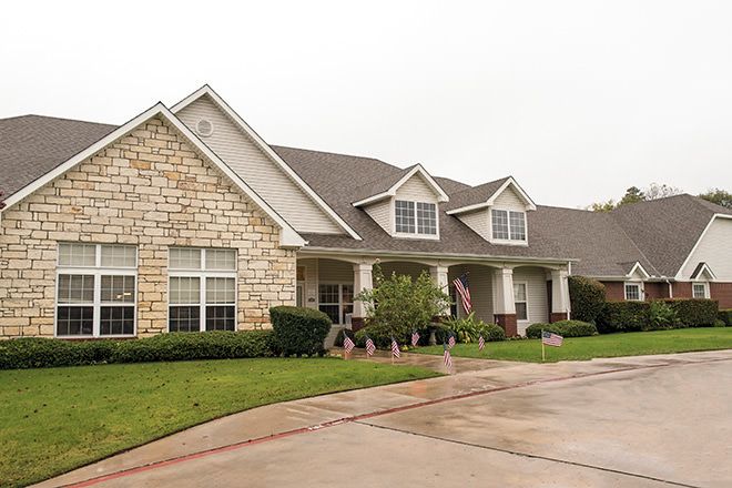 A suburban house with a stone facade and a neatly maintained front yard.