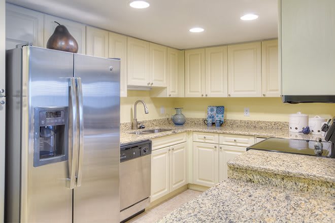 A modern kitchen with stainless steel appliances and light cabinetry.