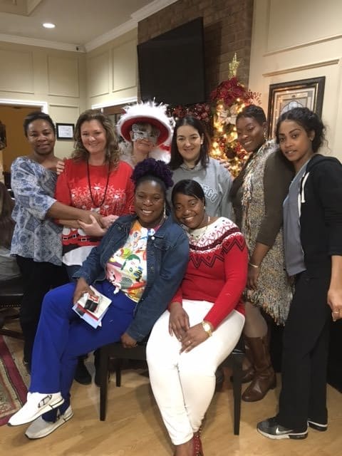A group of people posing together in festive holiday attire, enjoying a Christmas celebration indoors.