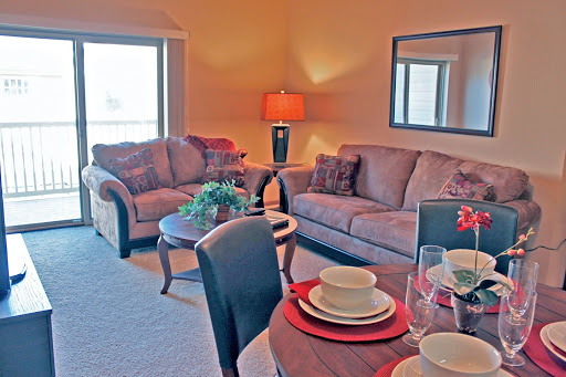 A cozy living room and dining area featuring comfortable sofas, a stylish lamp, and an inviting table setting.