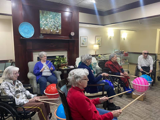 A group of elderly individuals participating in a music therapy session at a community center.