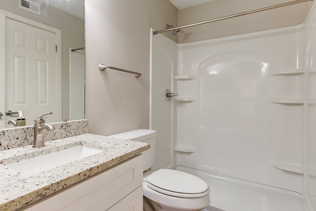 A modern and clean bathroom featuring a shower, toilet, and sink.