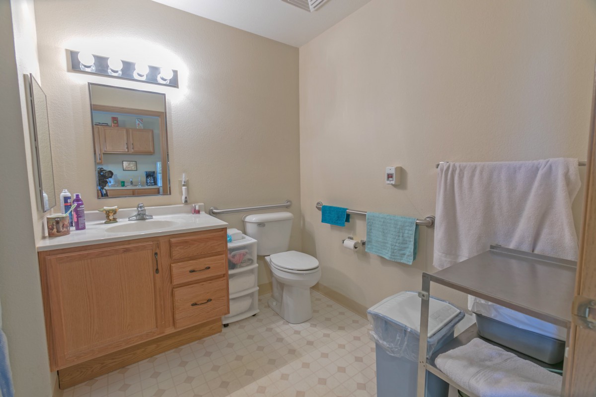 A clean and organized bathroom with wooden vanity, sink, and well-arranged towels.