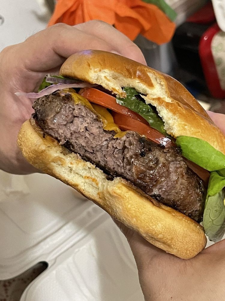 A juicy burger filled with fresh vegetables and a thick beef patty.