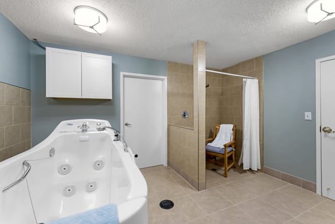 A modern bathroom featuring a jacuzzi and a walk-in shower with seating.