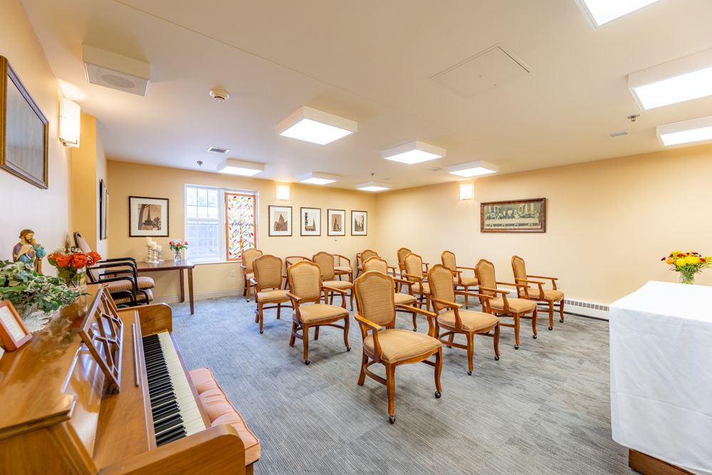 A small meeting room with arranged chairs and a piano.