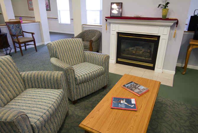 A cozy living room with chairs and a fireplace.
