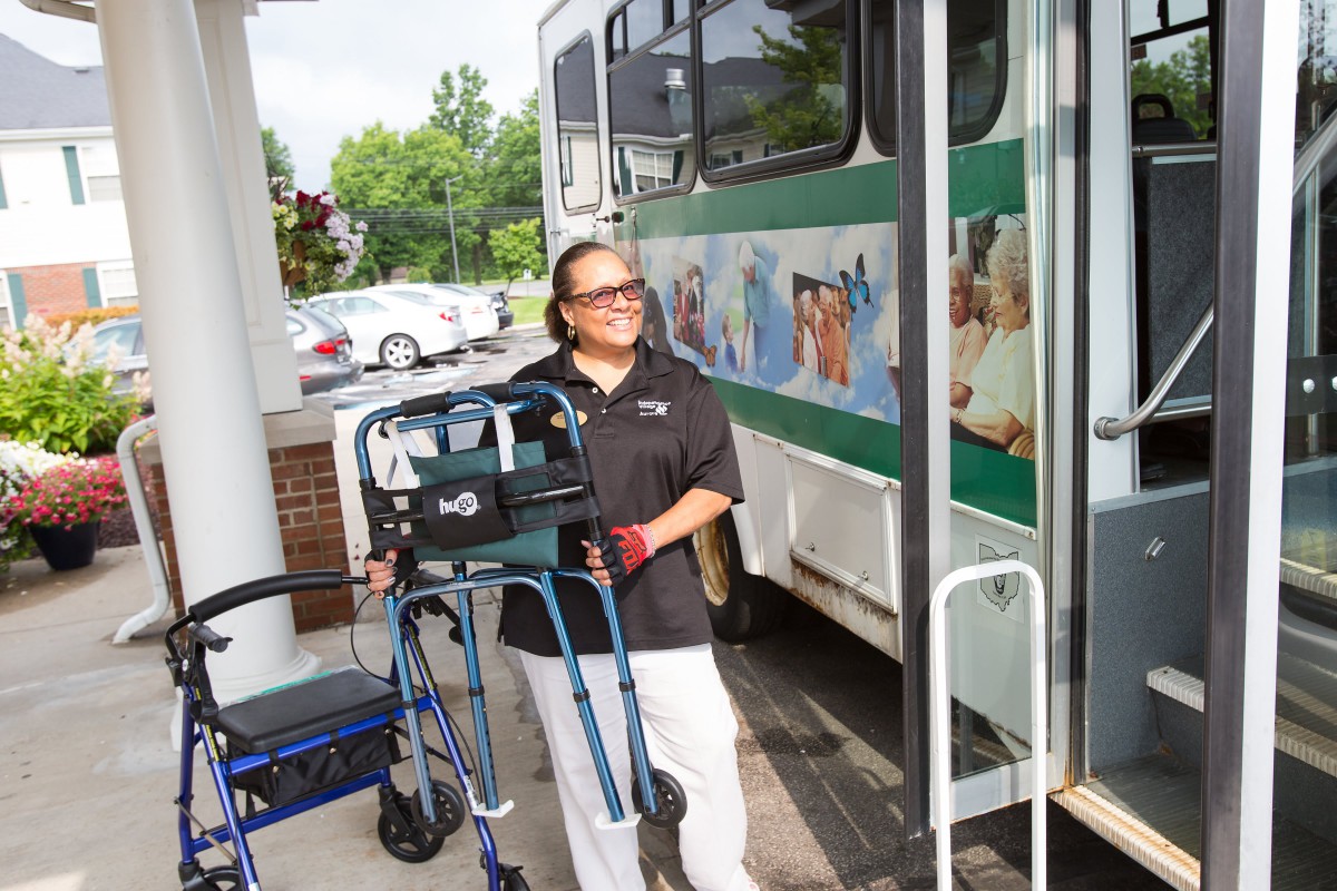 A person with a mobility aid is preparing to board a bus equipped with accessibility features.