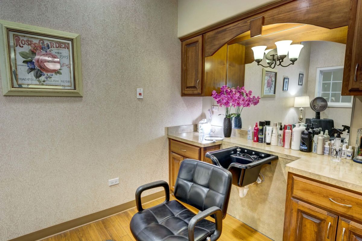 A salon setup with a chair, sink, mirror, and various hair products.