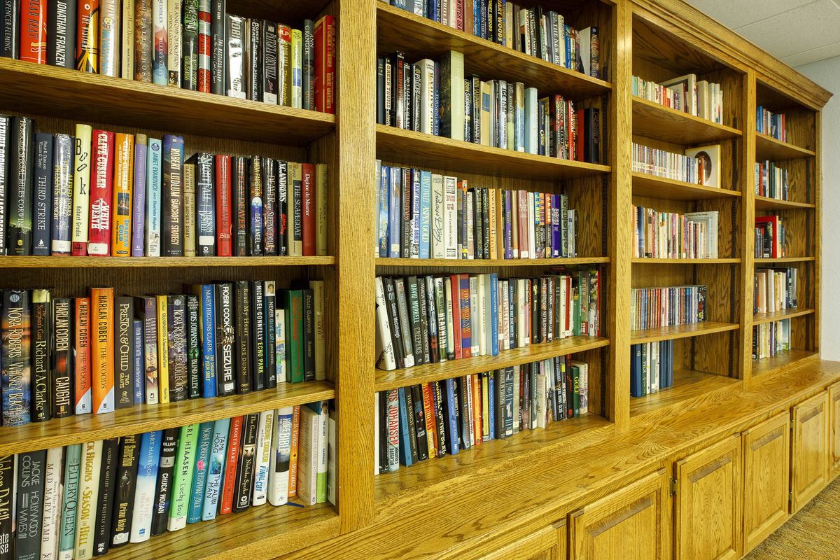 A large wooden bookshelf filled with a variety of books.