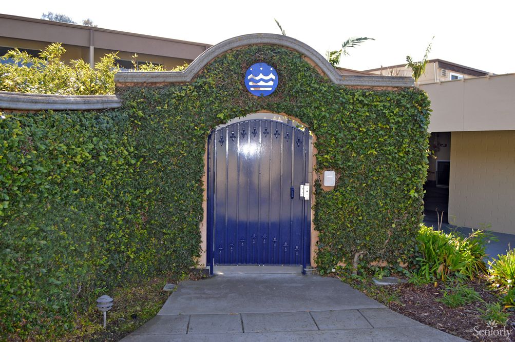 Ivy-covered entrance with a striking blue door and archway.