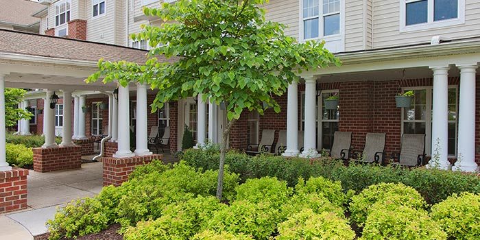 A charming house with a porch and lush greenery.